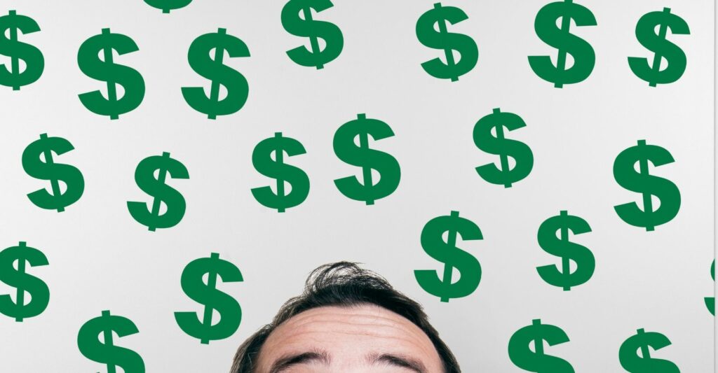 An image showing just the top of a person's head - from the eyebrows upwards - looking up. The rest of the image is filled with green dollar signs.