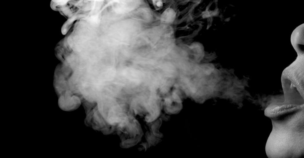 A close up image of a patch of smoke blown out from someone's mouth from smoking.