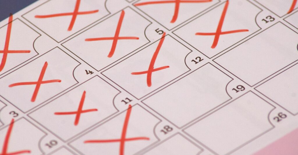 a close up photo of a simple calendar with red crosses over the majority of the dates