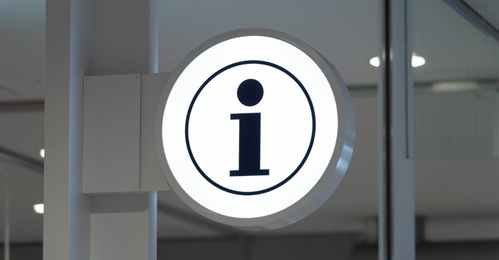 An white circular sign with the letter 'i' in the middle - an information sign