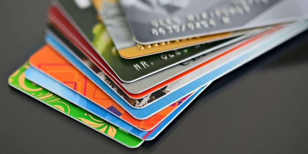 A close up shot of multiple debit or credit cards in spread out stack on a table.