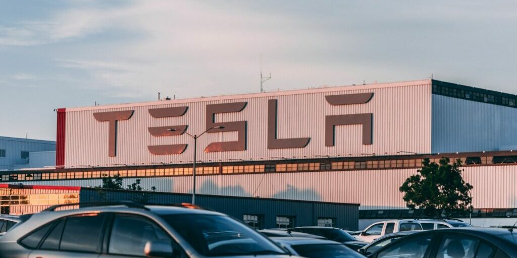 A photo of a tesla warehouse from the front, showing clearly, the Tesla company name.