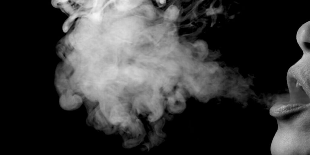 A close up image of a patch of smoke blown out from someone's mouth from smoking.