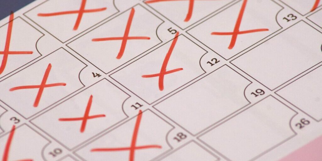 a close up photo of a simple calendar with red crosses over the majority of the dates