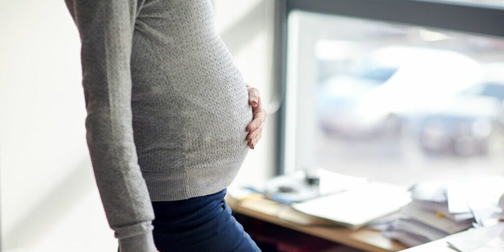 a close up image of a lady's baby bump.